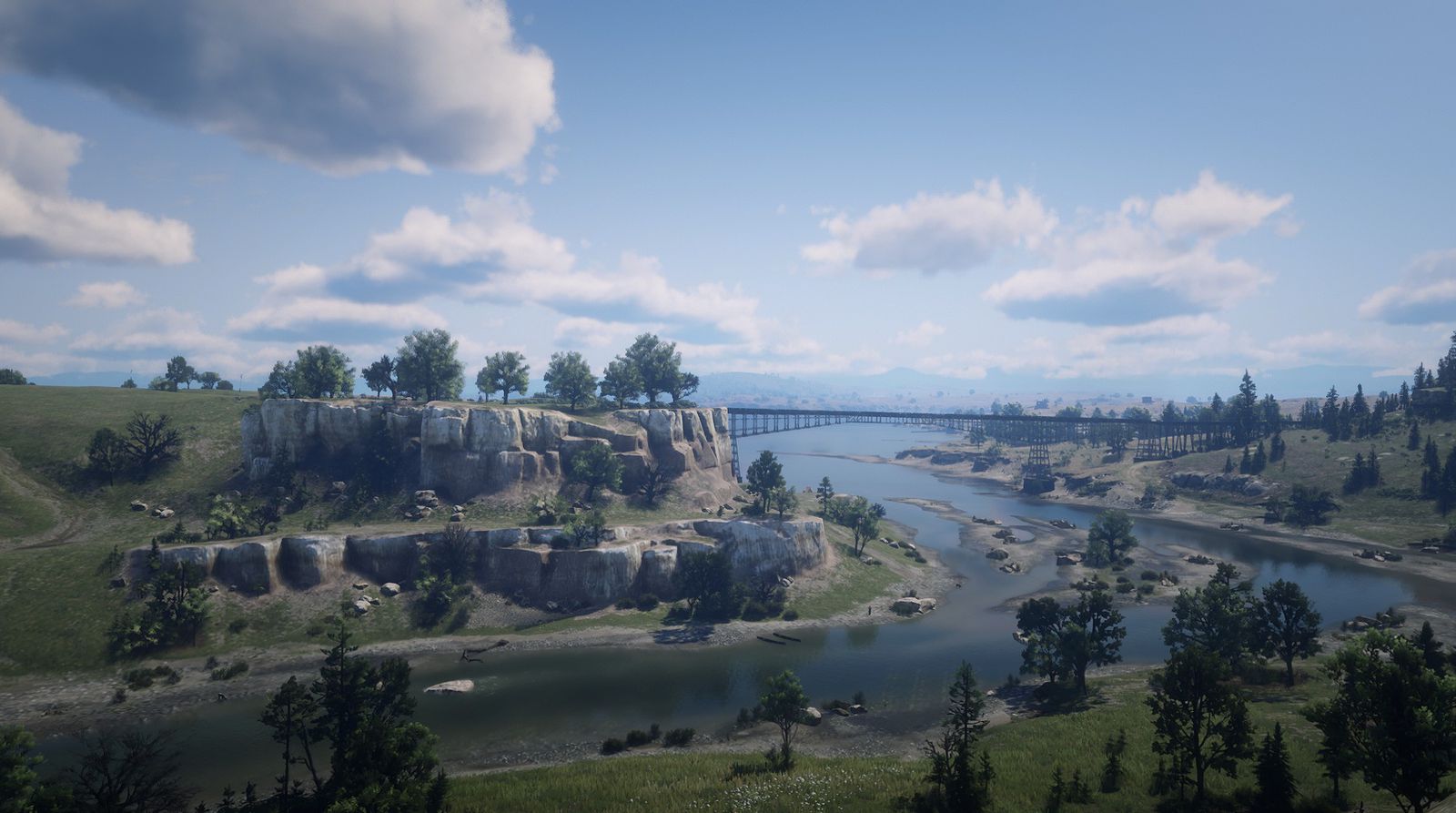 The Dakota River winding past pale limestone cliffs toward a long railway trestle under a bright sky